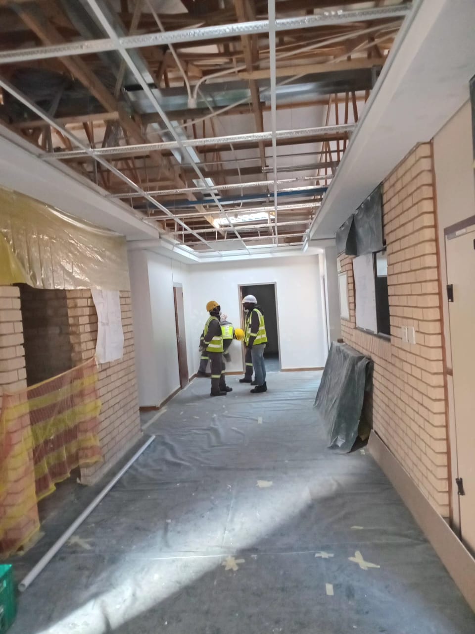 Construction workers in personal protective equipment inside a project building